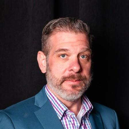 Portrait of Al Matesic in a blazer and checked shirt